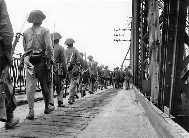 Bộ đội ta hùng dũng tiến qua cầu Long Biên vào tiếp quản Hà Nội, cùng lúc quân Pháp rút khỏi Hà Nội qua cây cầu này phía chiều bên kia, chiều 9/10/1954. Ảnh: Tư liệu TTXVN